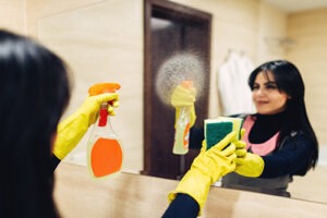 Image of woman cleaning with disinfectant after the flu